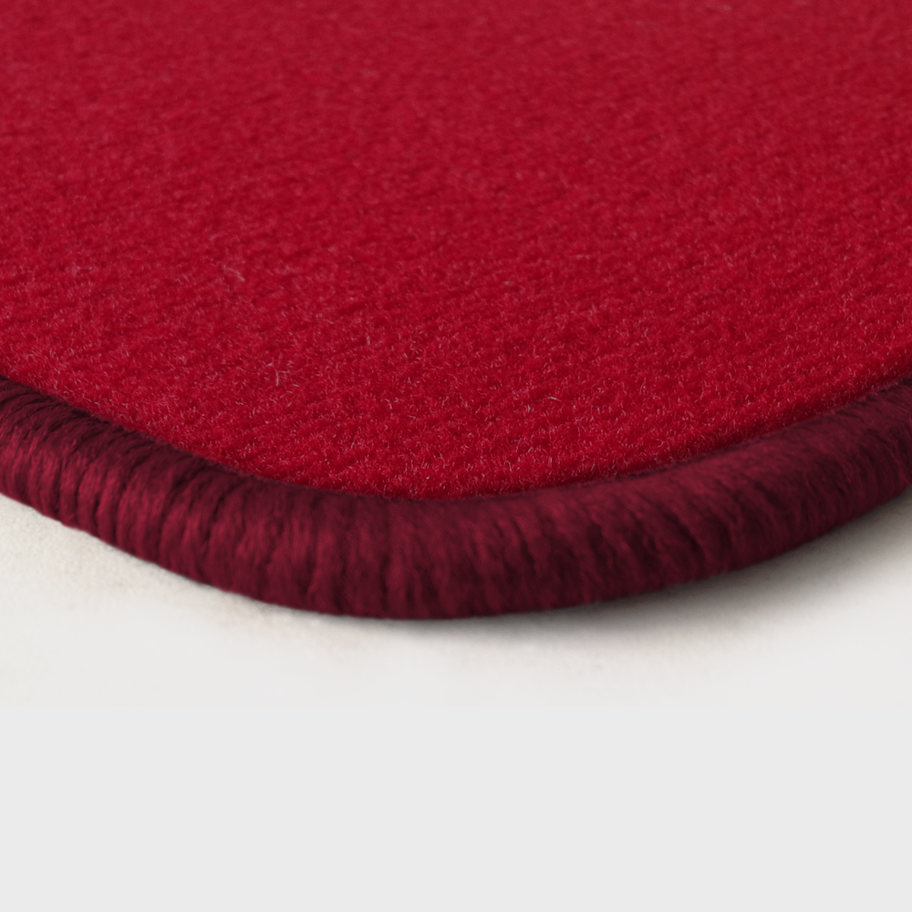 Eine Ecke als Beispiel einer Fussmatte Velours rot mit Rand in bordeaux.