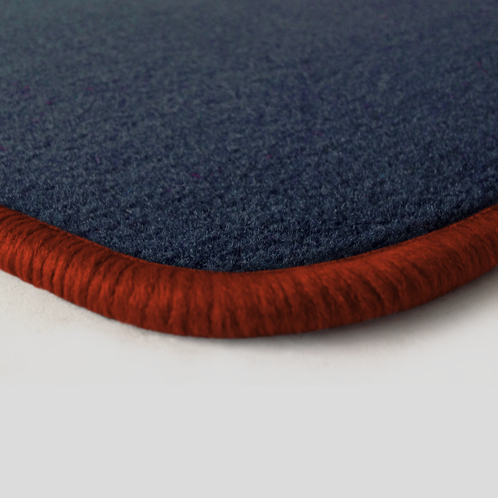 Eine Ecke als Beispiel einer Fussmatte Velours dunkelblau mit Rand in kupfer.