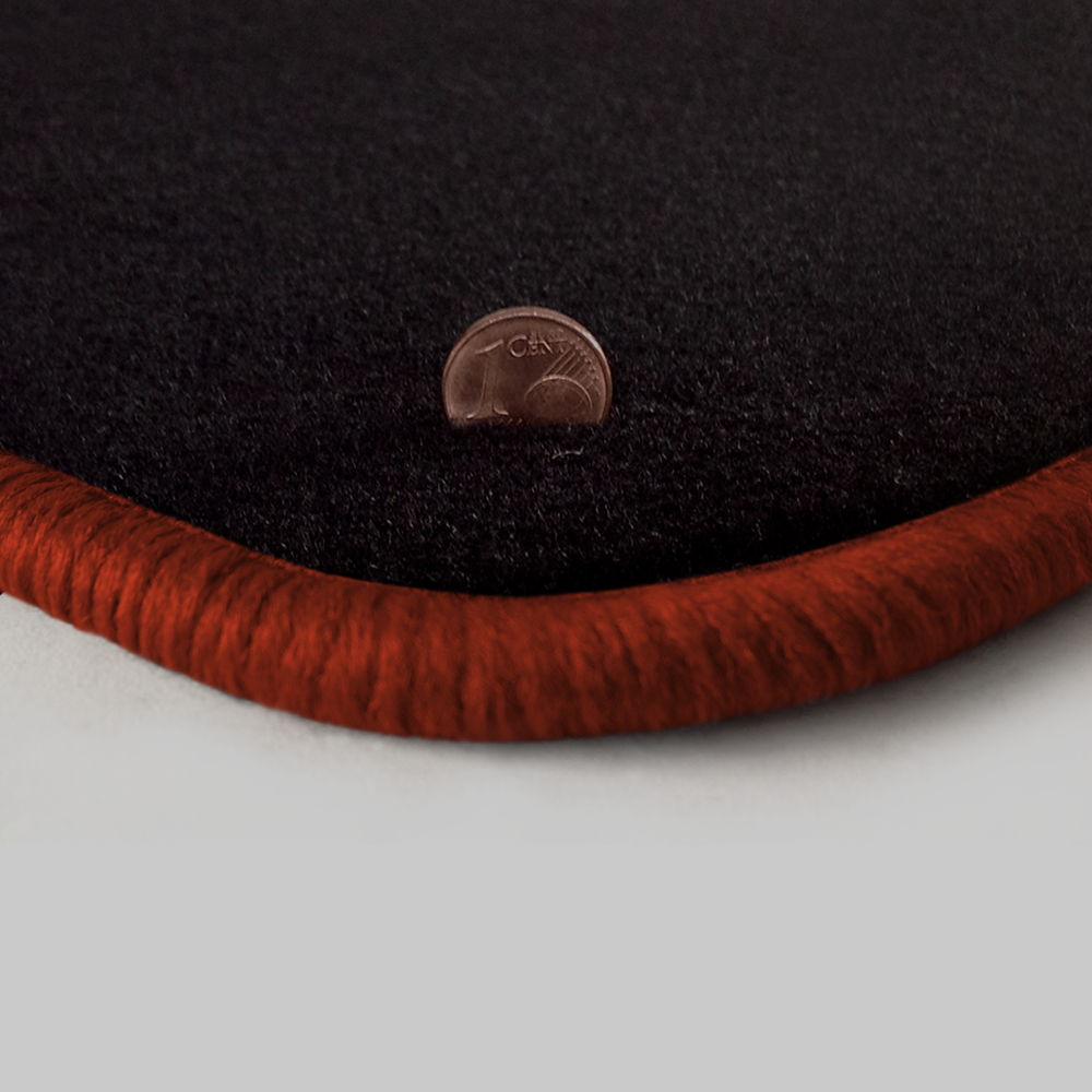 Eine Ecke als Beispiel einer Fussmatte Velours schwarz mit Rand in kupfer.