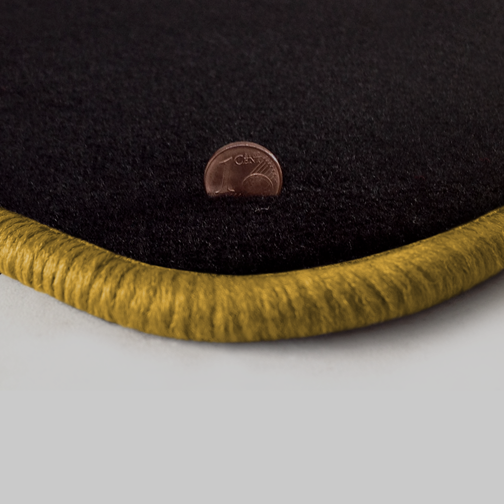 Eine Ecke als Beispiel einer Fussmatte Velours schwarz mit Rand in gold.