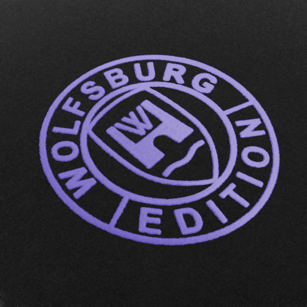 Das Wolfsburg Editions Logo auf einem schwarzen Teppich und das Logo ist in flieder.